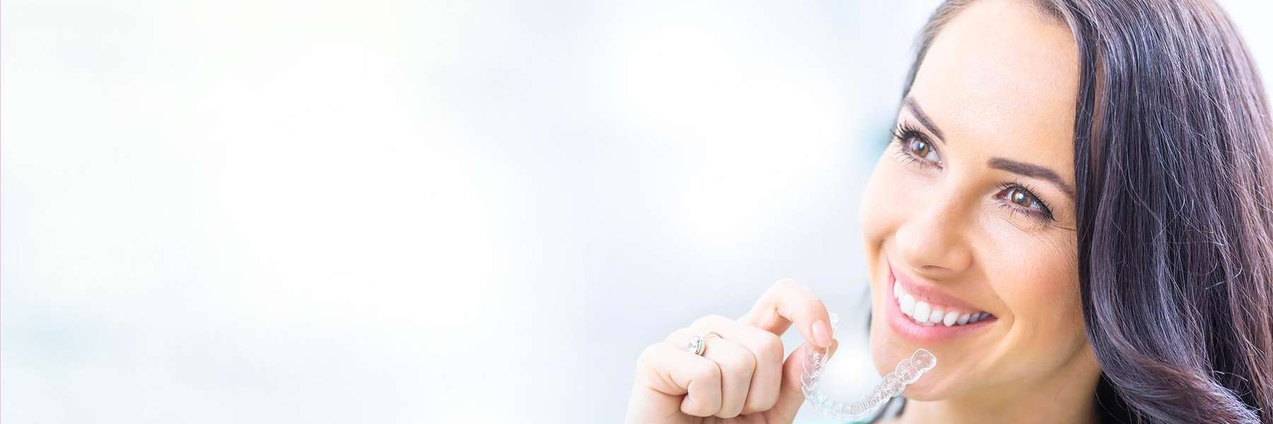 Lady holding Invisalign clear aligners In Beachwood, OH