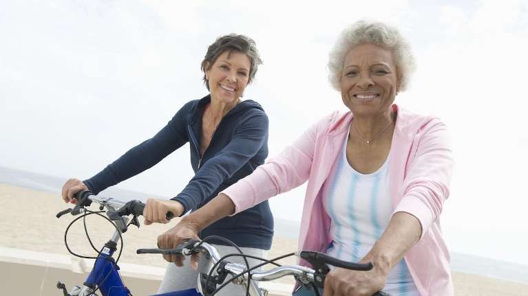 Ladies riding bicycles after getting dentures in Beachwood, Ohio