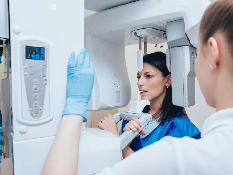 Dentist using Cone Beam Computed Tomography to get images of patients teeth in Beachwood, OH